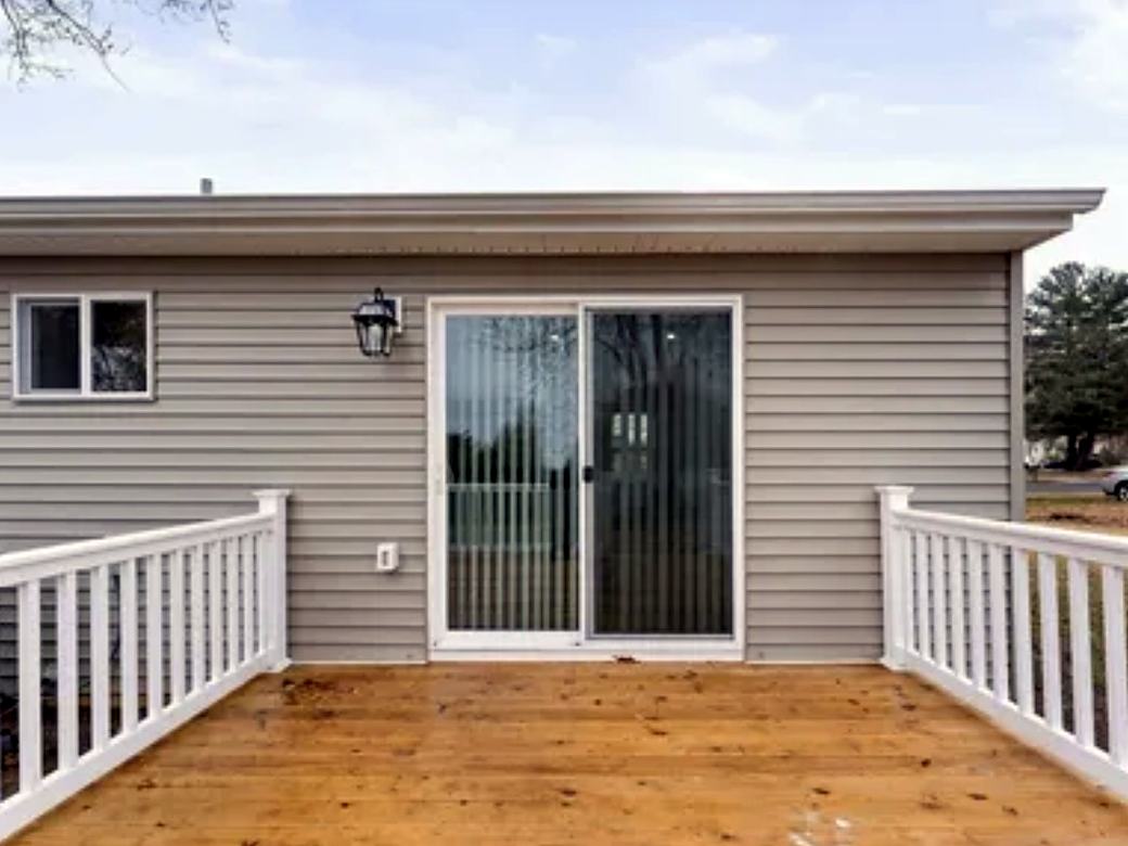 Close view of new deck boards and railings by a sliding door