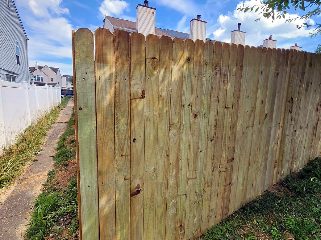 New wood privacy fence with dog ear pickets along a side yard