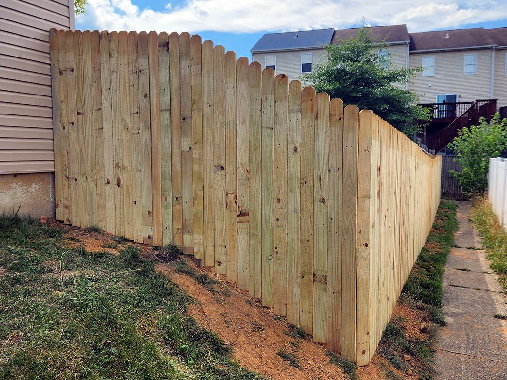 New wood privacy fence along a side yard next to a house