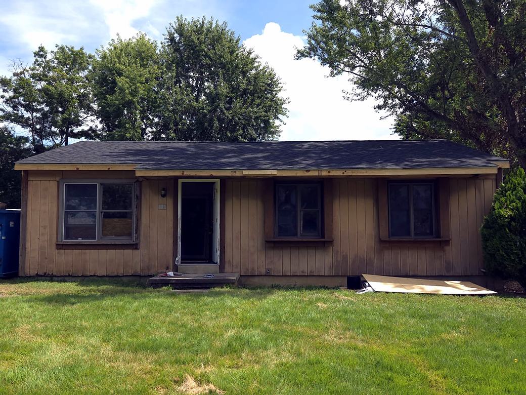 Ranch home with old wood panel siding before the work