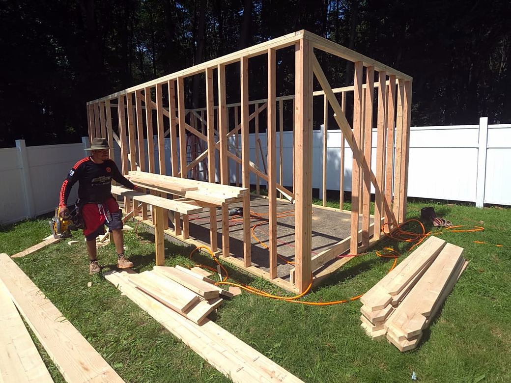 Timber Wolf crew member cutting lumber for a shed frame