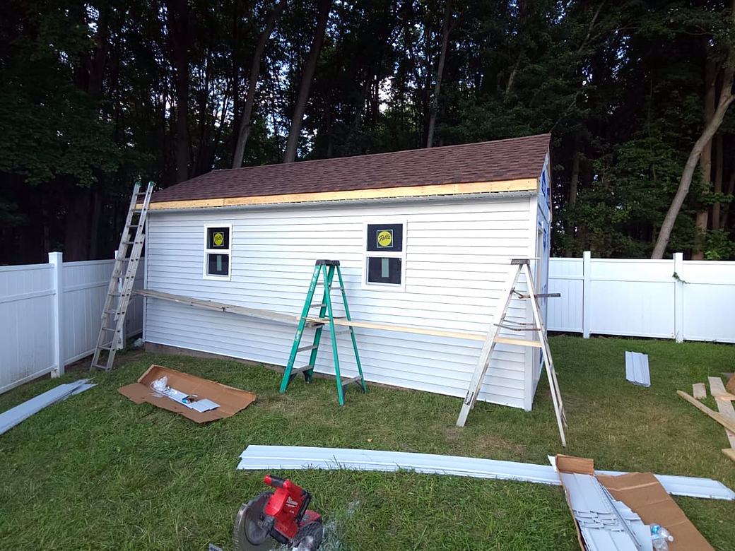 Shed with siding going on and new shingle roof