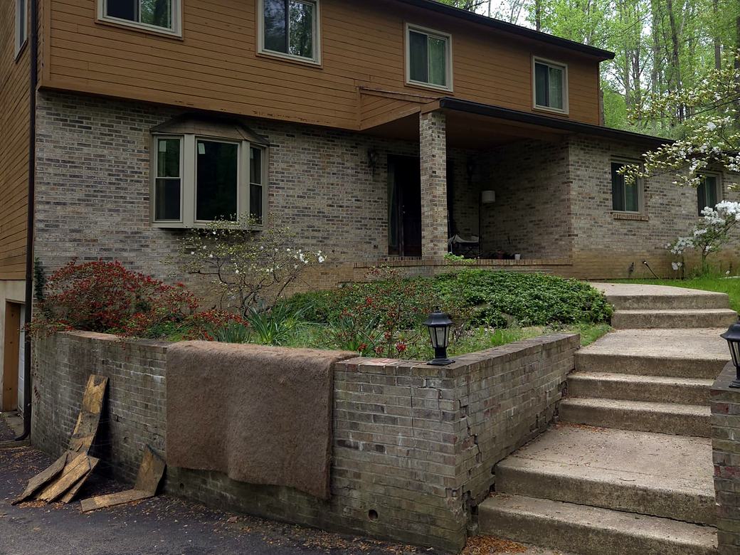 Stained and patched brick and block retaining wall before the work